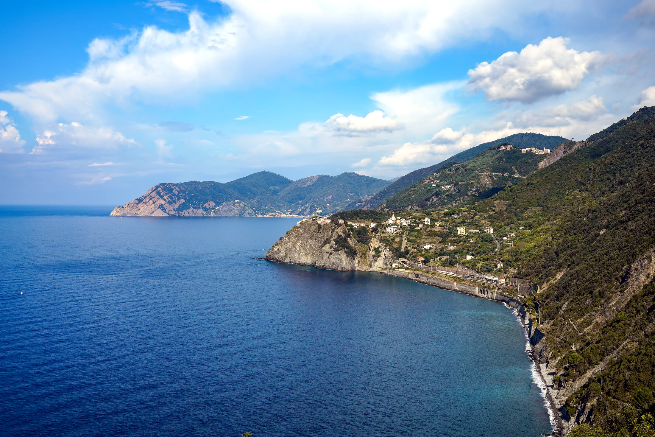 View NW from above Manarola : Corniglia Station and town, San Bernardino above, Monterosso and Punta Mesco in background. Cinque Terre , Liguria, Italy.